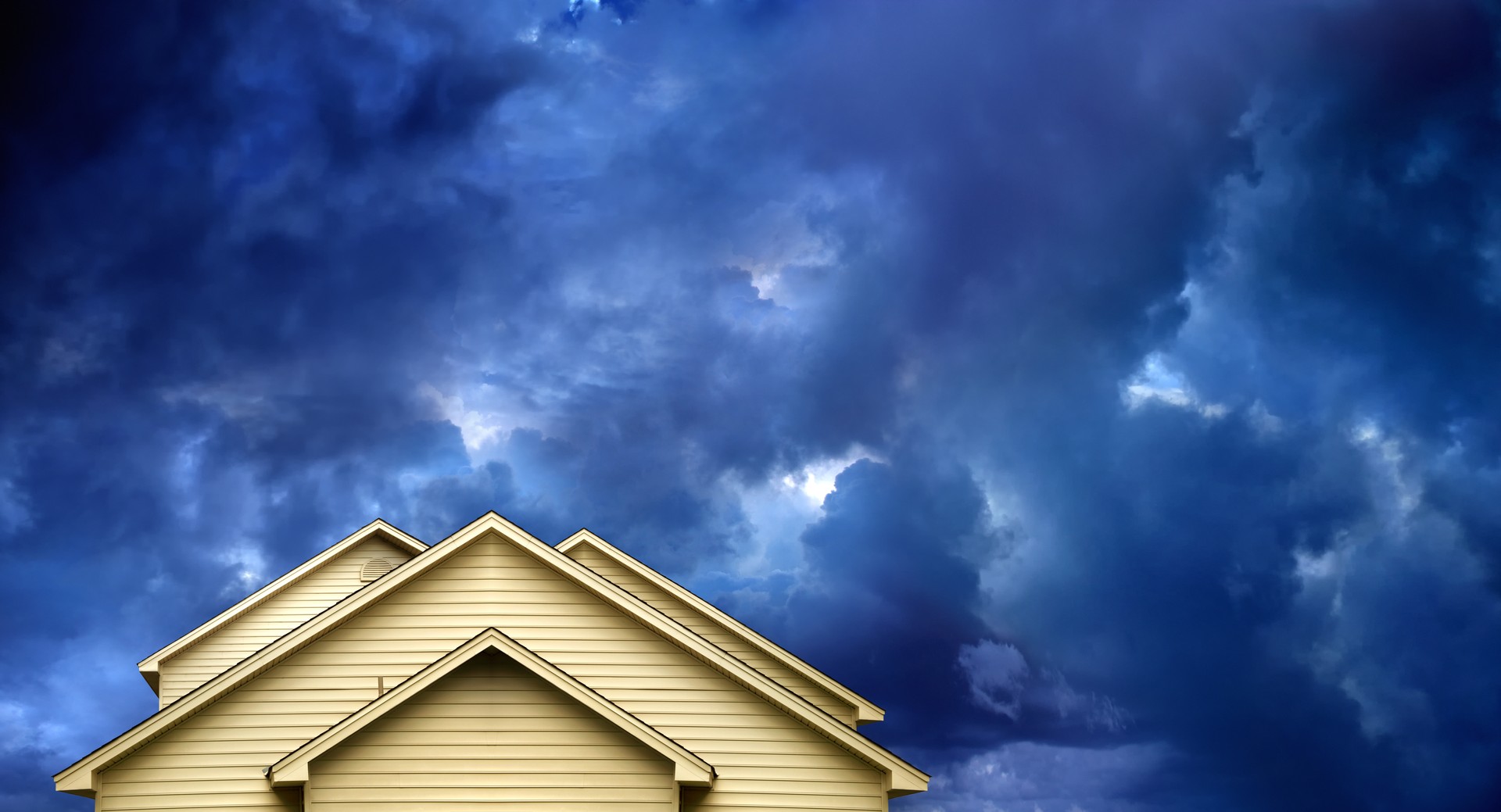 House roof top over dark dramatic storm sky