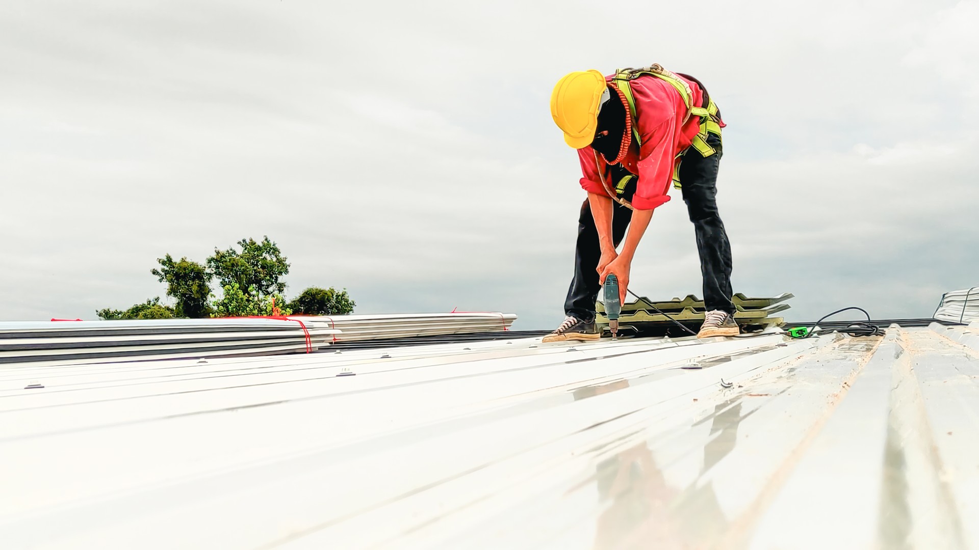 Construction worker install roof, Roofing tools, worke using Electric drill  replacement install roof roof plates.