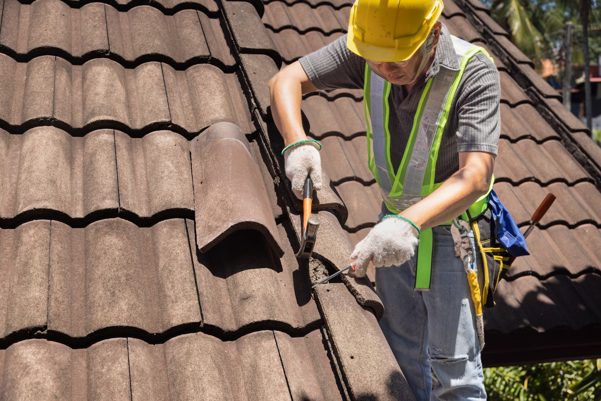 Worker man replace tile of the old roof. Repair roof concept.